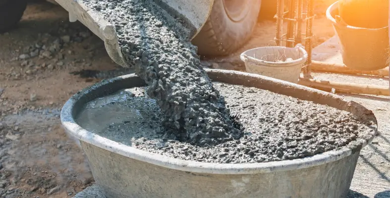 Image of concrete being poured into a bucket. 