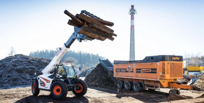 A bobcat telehandler in action at a waste site. 