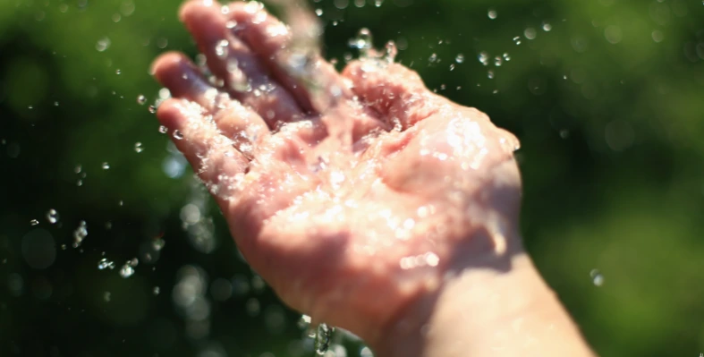 A_hand_being_showered_with_water