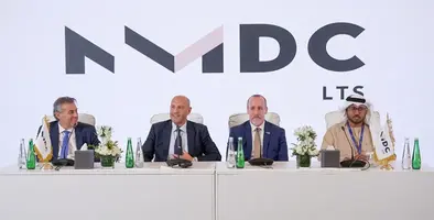 Four men sitting at a table for a signing ceremony