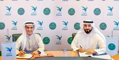 Two men sitting at a table, signing a few papers