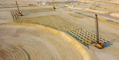A large-scale construction site featuring dynamic compaction operations.