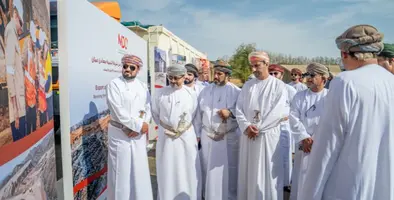 A group of Omani men dressed in traditional clothing at an outdoor event 