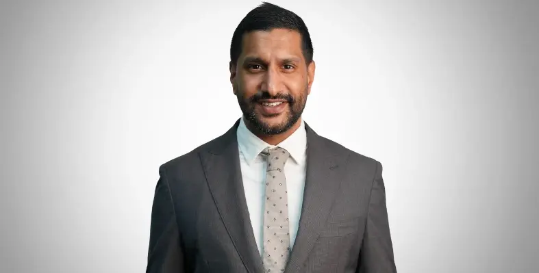 a_man_standing_behind_a_grey_background