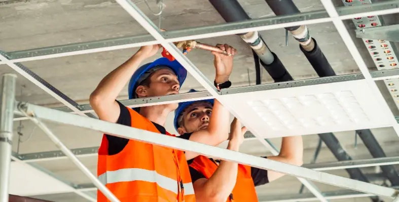 Two_men_wearing_hard_hats_inspecting_building_form